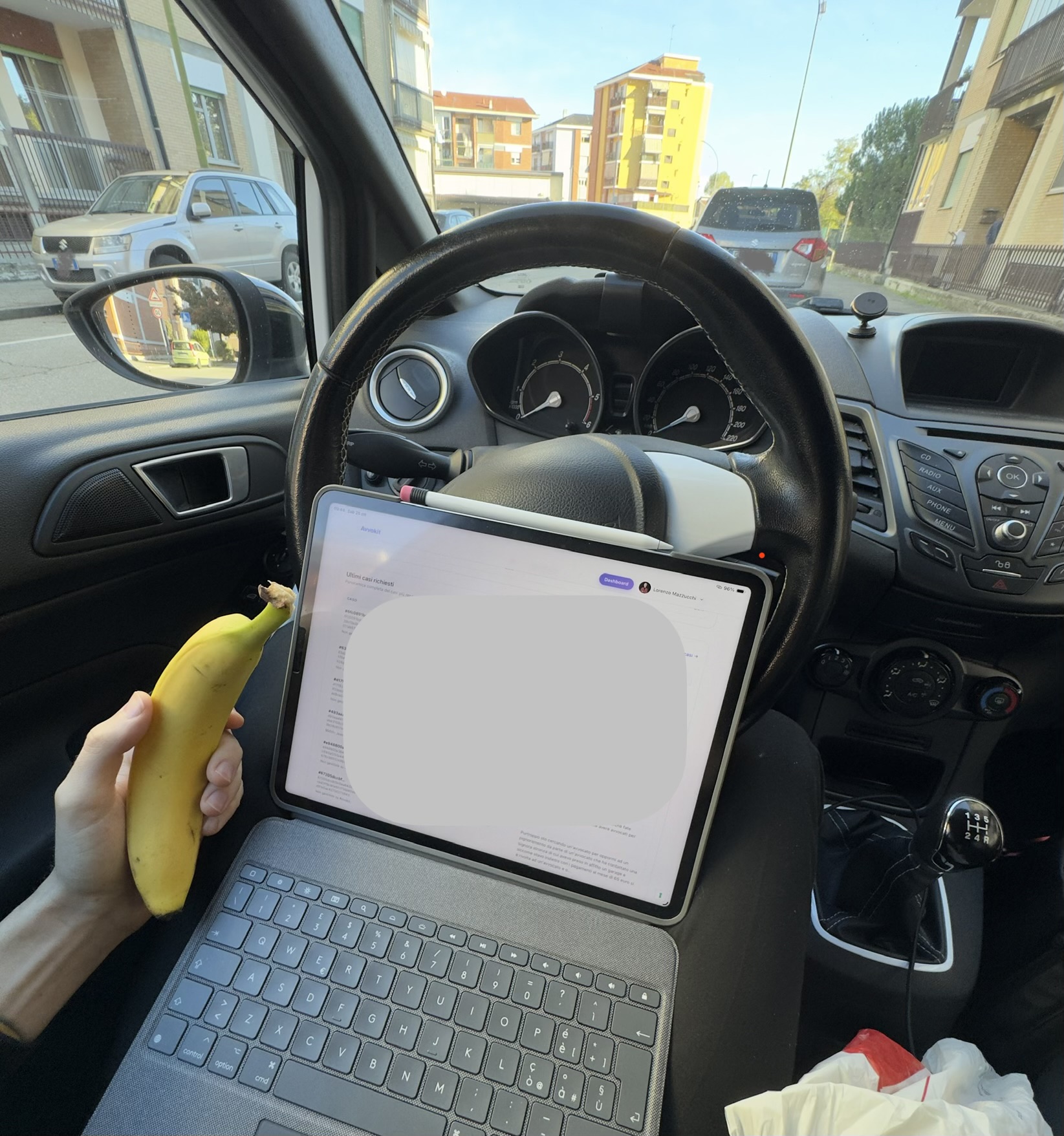 Al computer in pausa pranzo, in macchina, con una banana in mano